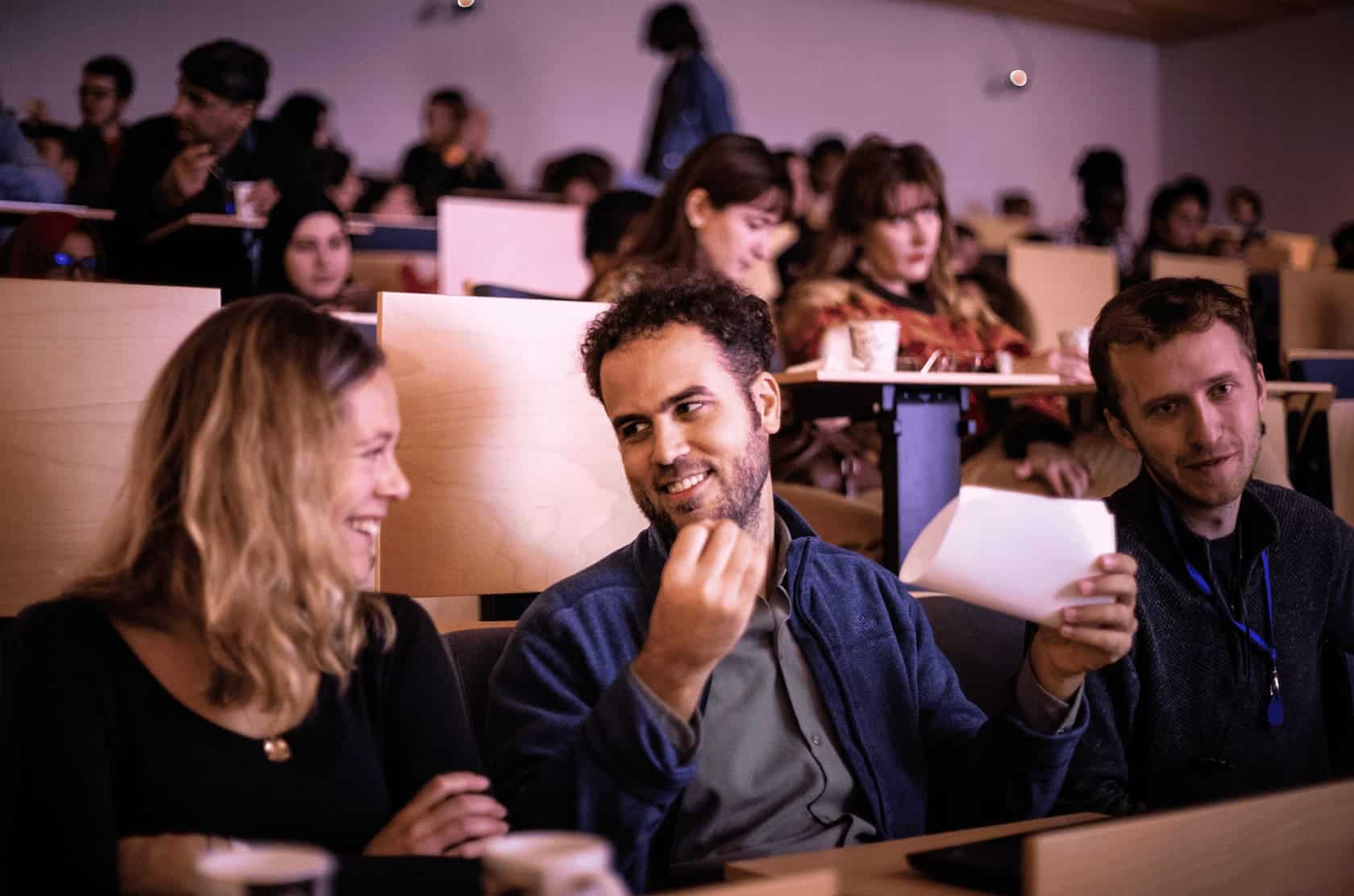Photo of colleagues exchanging smiles in the Learning Planet Institute amphitheater - illustration of the Raison d'être of organizations.